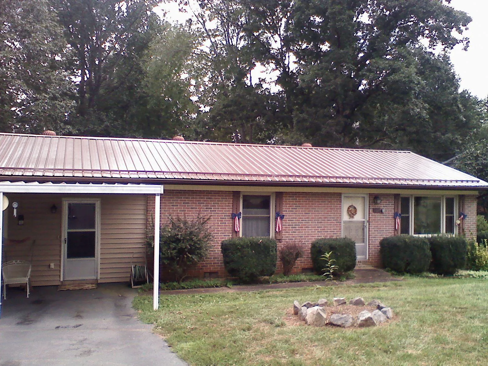 Bronze metal roof and carport on a brick ranch home — Roof Repair work by our crew in Odessa
